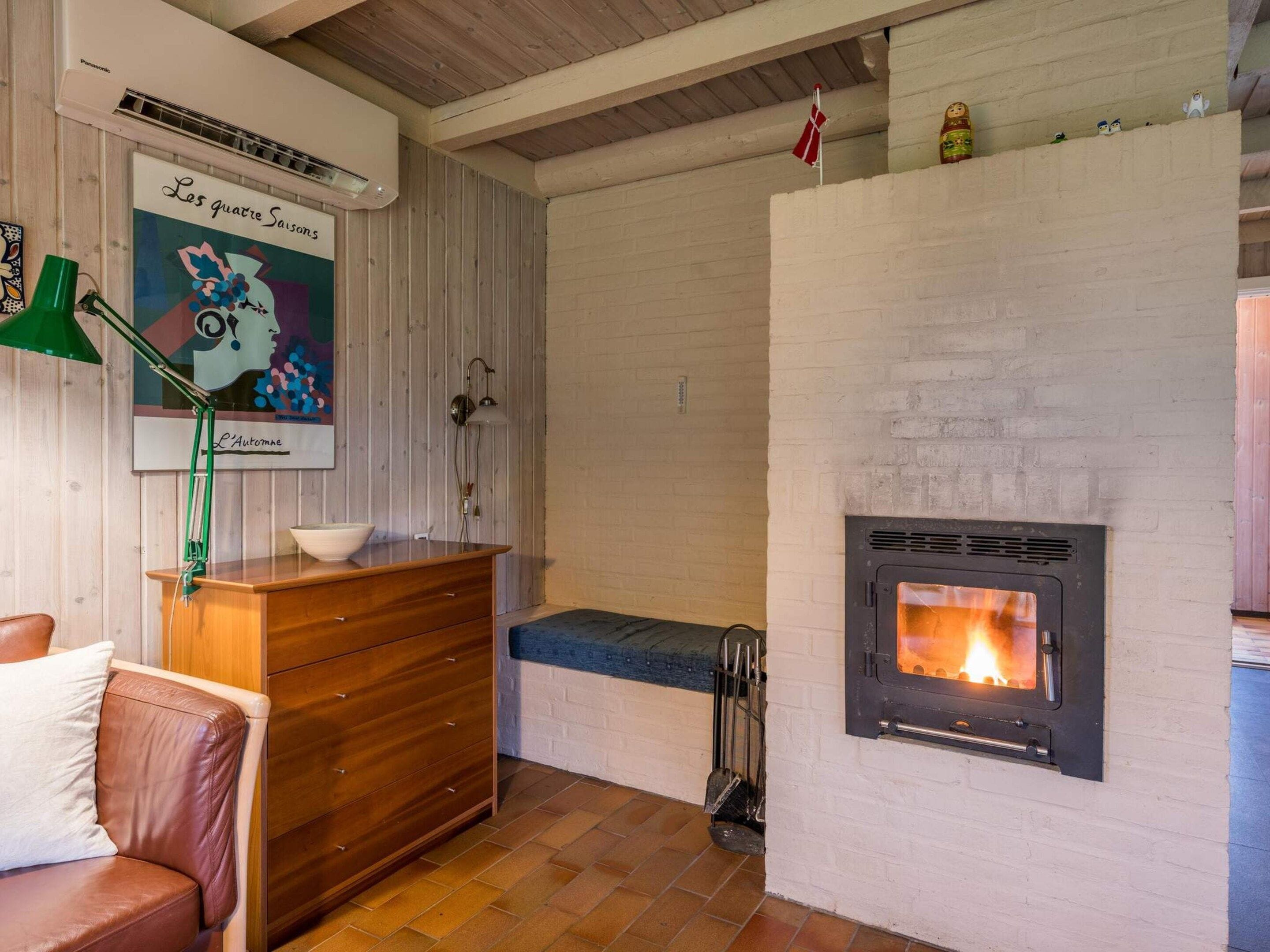 Ein gemütliches Zimmer mit Kamin, Holzmöbeln und einer Wandklimaanlage.
