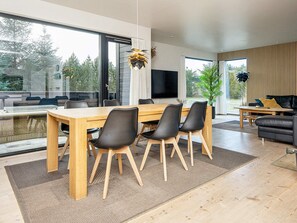 Un espace de vie moderne comprenant un coin repas, un canapé et un téléviseur.