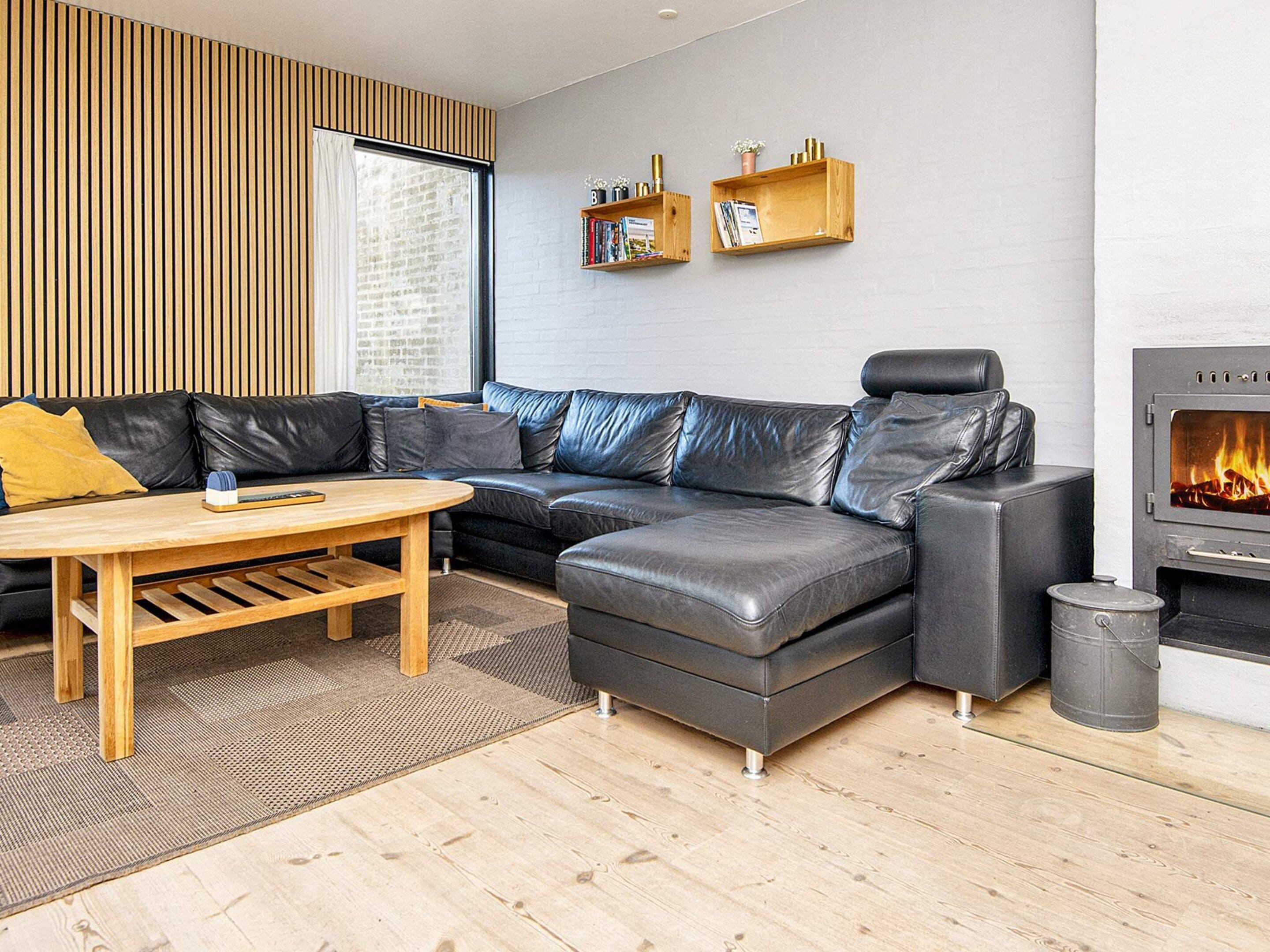 A modern living room with a sectional sofa, a wooden coffee table, and a fireplace.