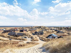 A coastal settlement with houses amidst dunes, a sandy path, and a clear sky. - 4 Star Holiday Home in Hvide Sande (Hvide Sande)