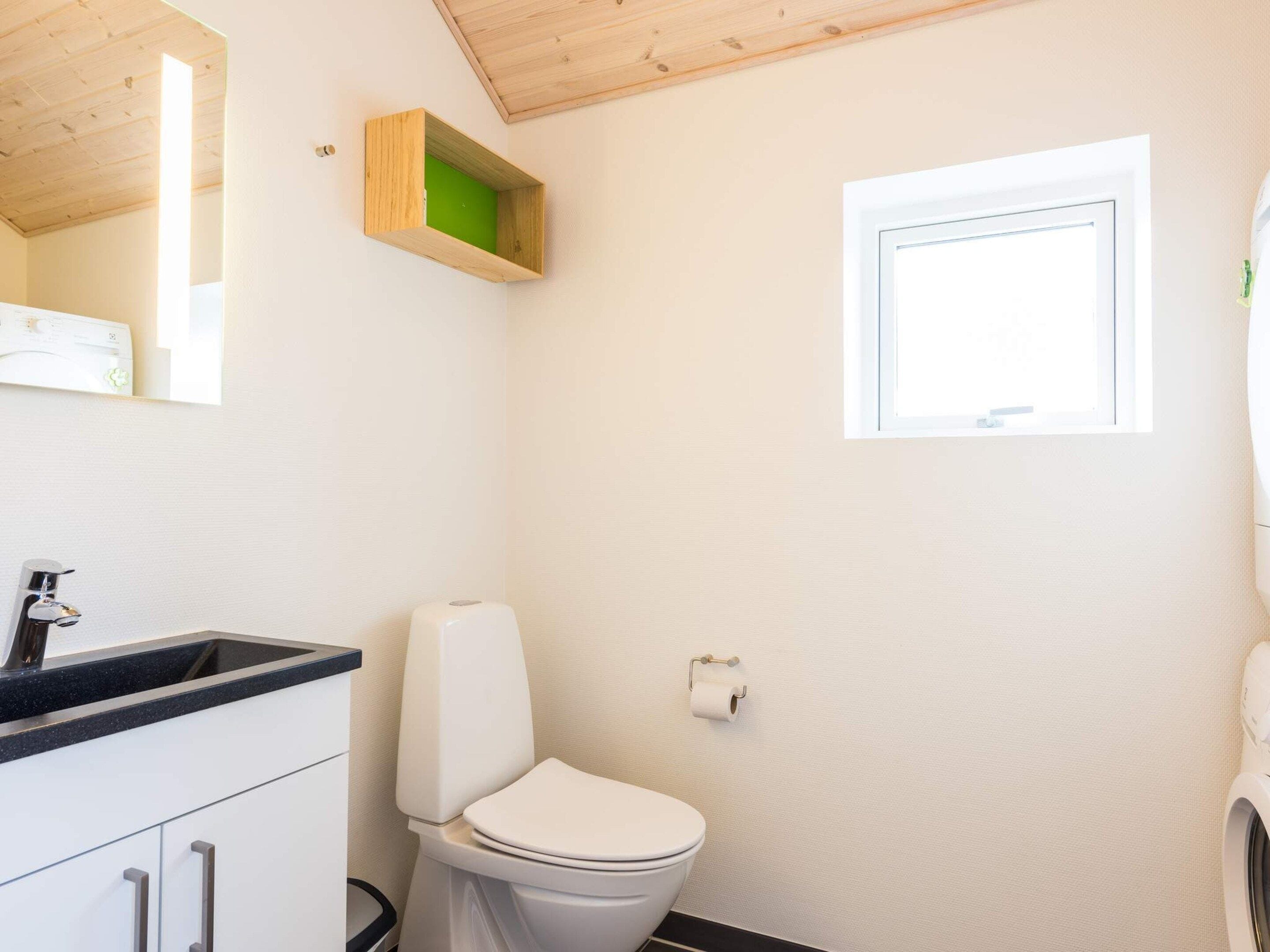 Un bagno con il water, un lavandino e una finestra.
