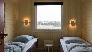 A small, single-room accommodation with two beds, a window, and wall-mounted lights. - 6 Person Holiday Home in Fano (Fano)