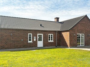 A brick building with a tiled roof, a white door, and a small window. - 4 Star Holiday Home in Tarm (Tarm)