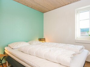 A bedroom with a bed, a window, and a wooden ceiling. - 4 Star Holiday Home in Tarm (Tarm)
