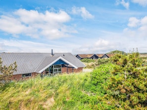 A modern building with a sloped roof, large windows, and a brick facade. - 4 Star Holiday Home in Henne (Henne)