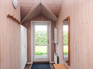 A wooden interior with a door leading outside, a radiator, and a mirror on the wall. - 5 Star Holiday Home in Hemmet (Hemmet)