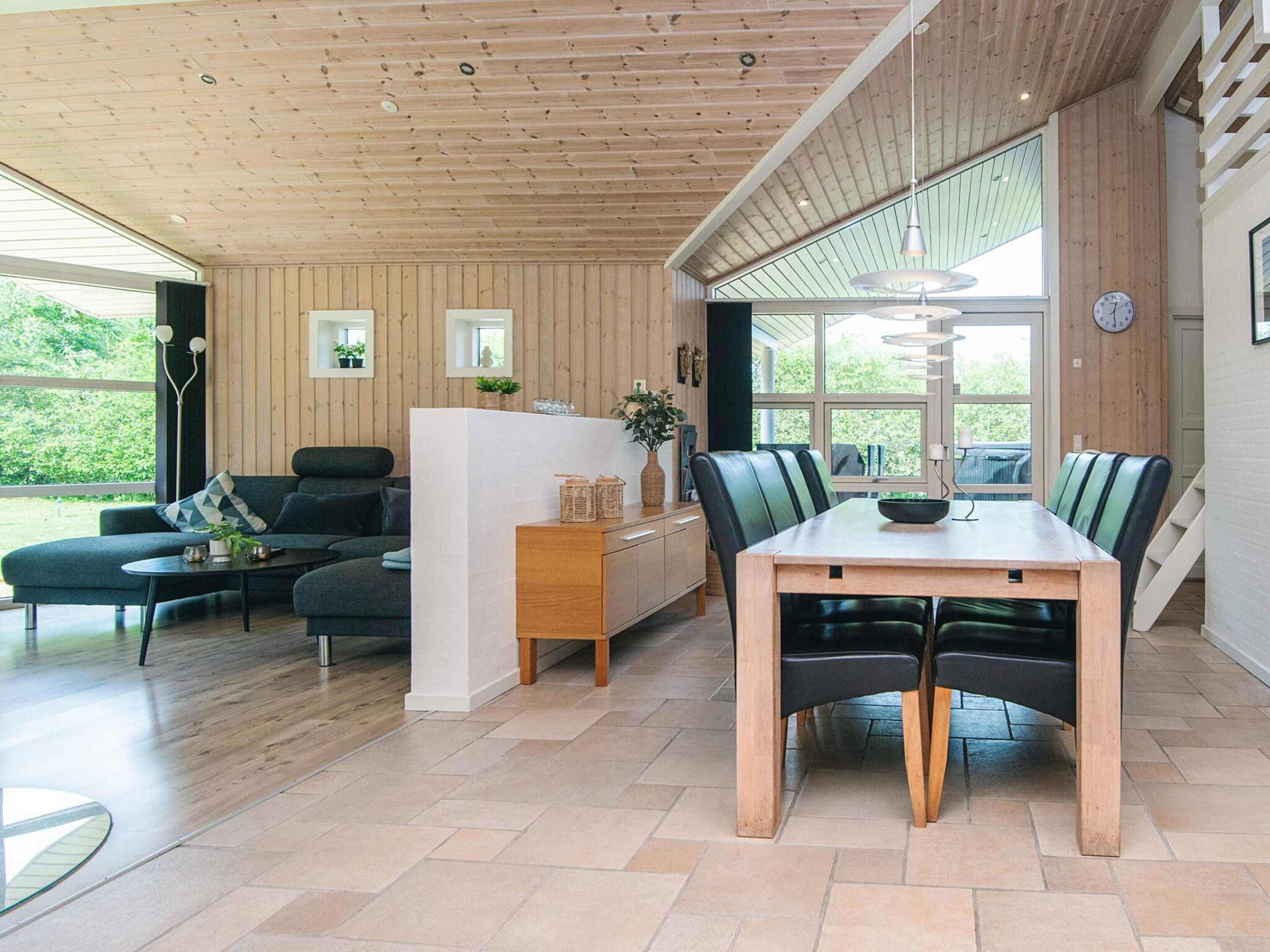 A modern interior with a dining area, a sofa, and a kitchen counter.