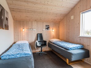 A room with two beds, a chair, and a window. - 5 Star Holiday Home in Tarm (Tarm)