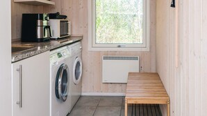 A compact kitchen with a washing machine, a microwave, and a small window. - 4 Star Holiday Home in Oksbol (Oksbol)