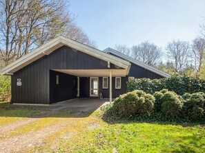 A black building with a covered entrance, a door, and a number '12' sign. - 8 Person Holiday Home in Oksbol (Oksbol)
