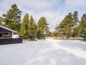 A snow-covered landscape with a building, trees, and a clear sky. - 4 Person Holiday Home in Blavand (Blavand)