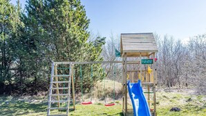 Un parque infantil con un tobogán de madera y una escalera.