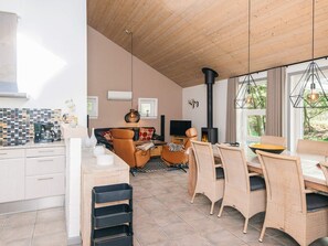 Une cuisine moderne avec un coin repas, une cheminée et une vue sur l’extérieur.