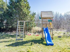 A playground with a slide and a climbing structure. - 5 Star Holiday Home in Norre Nebel (Norre Nebel)