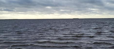 A beach with waves and a cloudy sky.