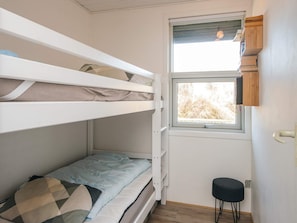 A bunk bed room with a window and a small stool. - 4 Person Holiday Home in Fano (Fano)
