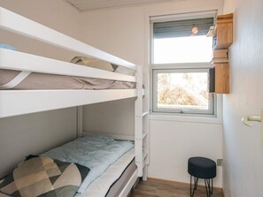 A bunk bed room with a window, a small stool, and a wooden shelf. - 4 Person Holiday Home in Fano (Fano)