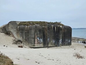 En betongkonstruktion med graffiti på en strand.