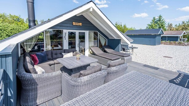 Una zona relax esterna moderna e accogliente, con un ampio e confortevole angolo salotto e un tavolino.