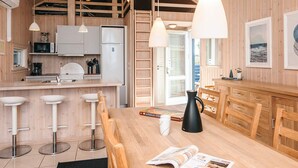 A wooden interior with a kitchen, dining area, and a loft space. - Holiday Home in Tarm (Tarm)
