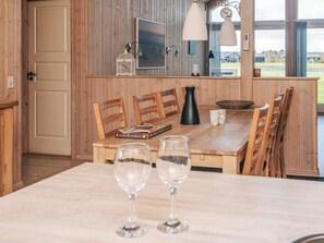 A wooden dining area with a table, chairs, and a view of the outdoors. - Holiday Home in Tarm (Tarm)