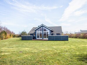 A modern house with a large glass front, surrounded by a well-maintained lawn. - Holiday Home in Tarm (Tarm)