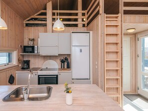 A compact kitchen with a sink, stove, microwave, and refrigerator. - Holiday Home in Tarm (Tarm)