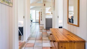 A hallway with a wooden bench, white walls, and a tiled floor. - 4 Star Holiday Home in Henne (Henne)