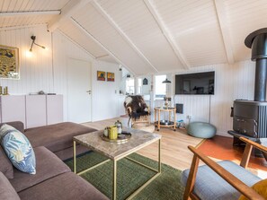 A cozy living room with a sofa, a coffee table, and a fireplace. - 4 Star Holiday Home in Fano (Fano)