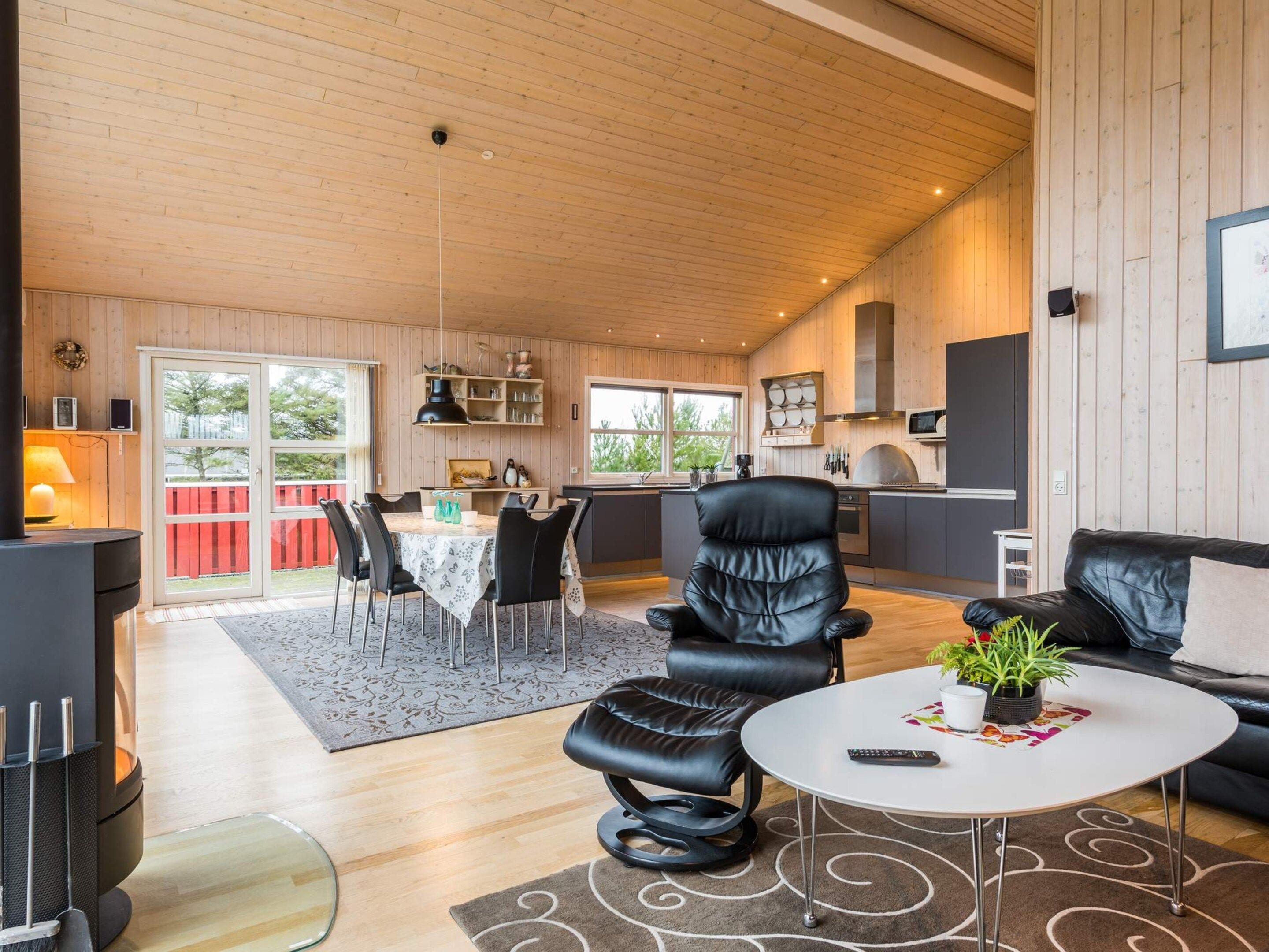A modern interior with a dining area, kitchen, and seating space.