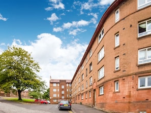 A multi-story residential building with a brick facade, multiple windows, and a tree in the foreground. - Graceful Apartment in Greenock near Newark Castle (Greenock)