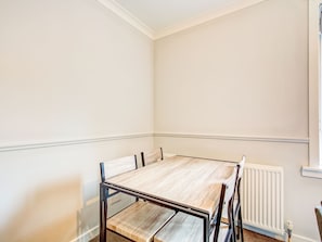 A room with a wooden table and chairs, a radiator, and a window. - Graceful Apartment in Greenock near Newark Castle (Greenock)