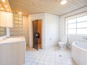A bathroom with a toilet, a bathtub, and a sink. - 4 Star Holiday Home in Tarm (Tarm)
