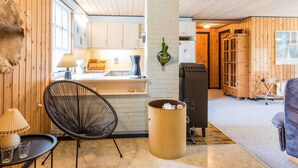 A cozy room with wooden walls and a kitchen area. - 6 Person Holiday Home in Norre Nebel (Norre Nebel)