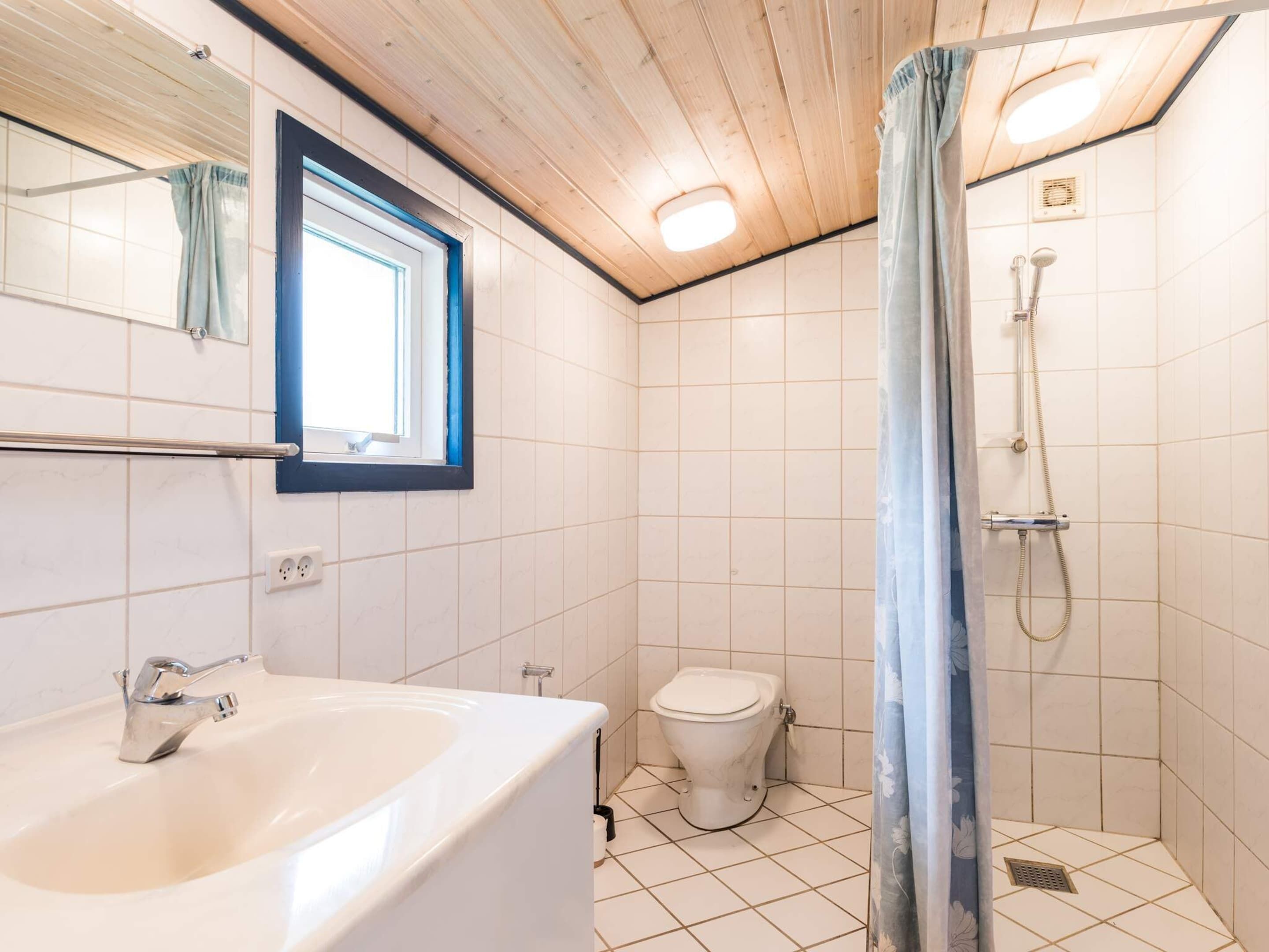 A bathroom with a bathtub, toilet, and shower.