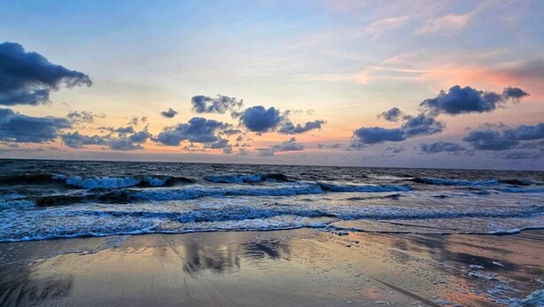 A beach with waves, a clear sky, and clouds. - 6 Person Holiday Home in Norre Nebel (Norre Nebel)