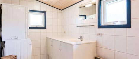 A compact kitchen with a built-in stove, a sink, and a window.