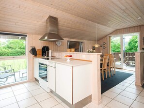 A modern kitchen with a central island, a built-in oven, and a coffee machine.