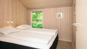 A bedroom with a bed, a window, a door, and a wall-mounted light fixture. - 6 Person Holiday Home in Tarm (Tarm)