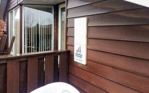 Eine Holzfassade mit Fenster und einem Schild.