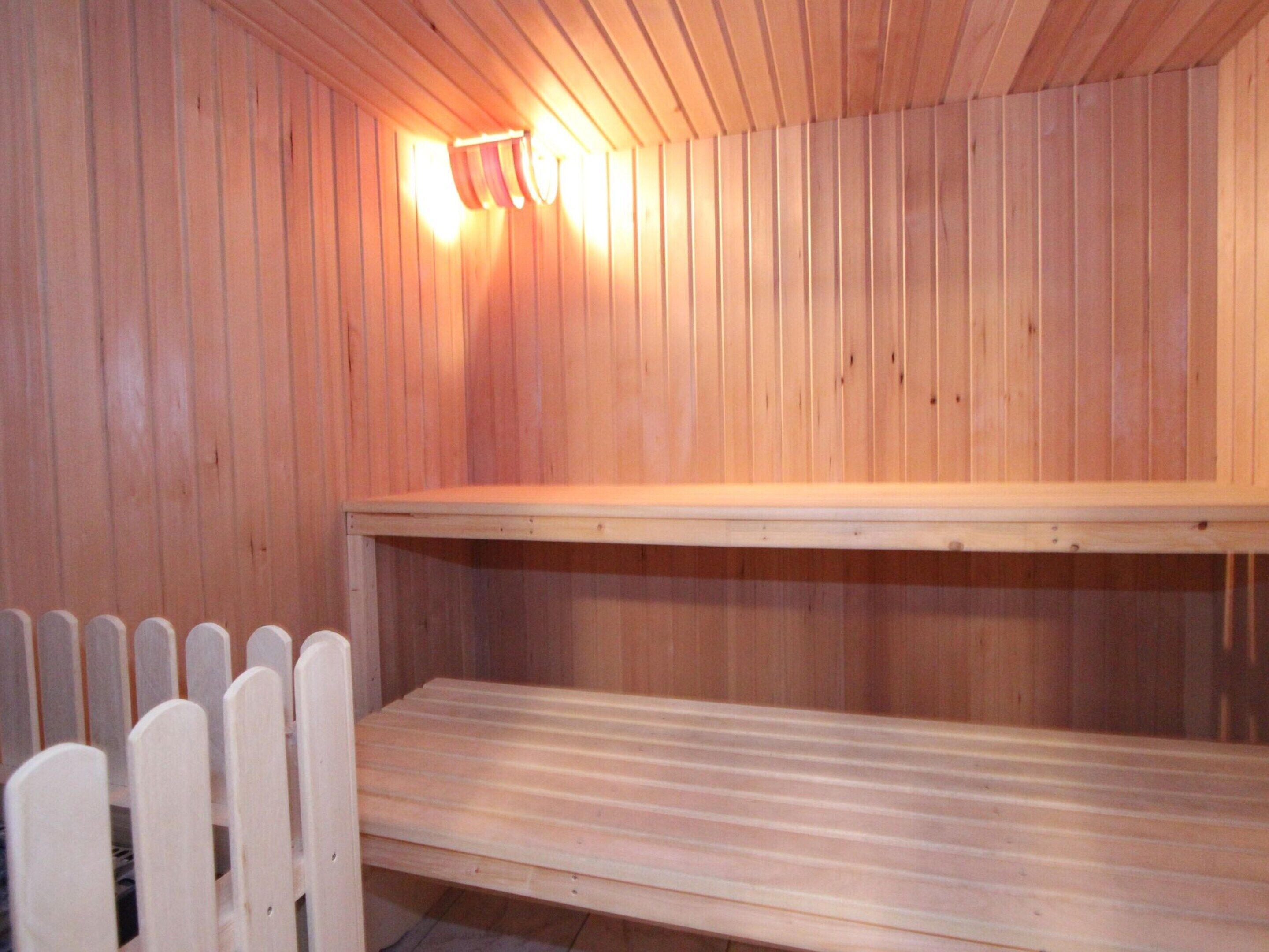 Una sala de sauna con paredes y bancos de madera.
