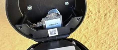 A black object with a QR code and a label with a number.