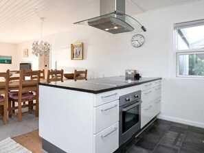 Enjoy cooking in this well-equipped kitchen with a central island, stainless steel range hood, and adjacent dining area.