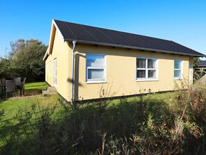 A single-story yellow house with a dark roof, white windows, and a visible gutter. - 8 Person Holiday Home in Skagen (Skagen)