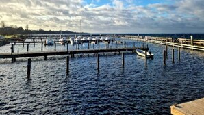 A marina with boats docked at wooden piers under a cloudy sky.