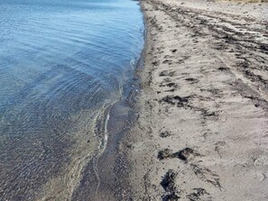 A beach with clear water and a sandy shore.