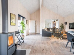 A modern living room with a wood-burning stove, seating area, and a television.