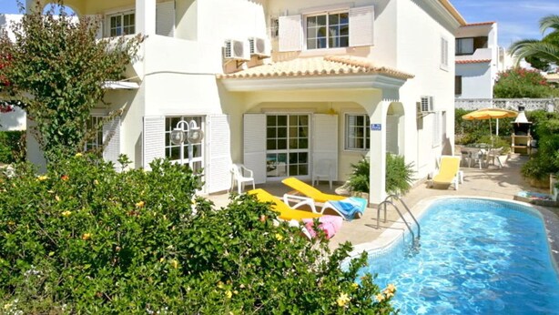 A two-story building with a swimming pool, outdoor seating, and a covered patio area. - Beautiful Villa Located Less Than Five Minutes Walk From the Old Village (Loulé)