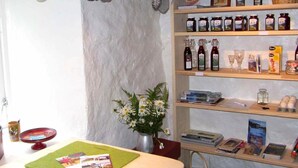 A cozy interior with shelves displaying various products, a table with a green placemat, and a vase with flowers. - 4 Person Holiday Home in Utvik (Stryn)