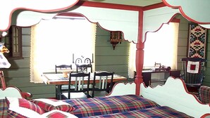A room with a four-poster bed, a dining table with chairs, and a window with curtains. - 4 Person Holiday Home in Utvik (Stryn)